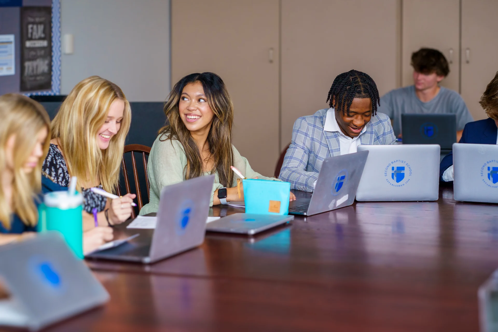 Group of young people looking at laptops in a classroom